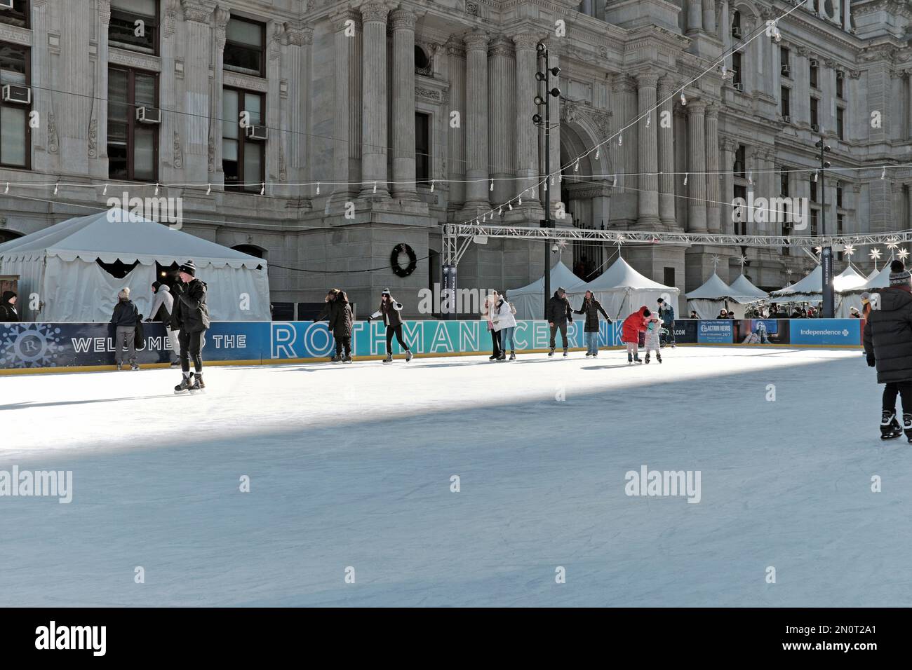 Die saisonale Rothman Ice Rink im Dilworth Park, Teil des Philadelphia Center City District, zieht Schlittschuhläufer zur Winterbahn im Freien an. Stockfoto