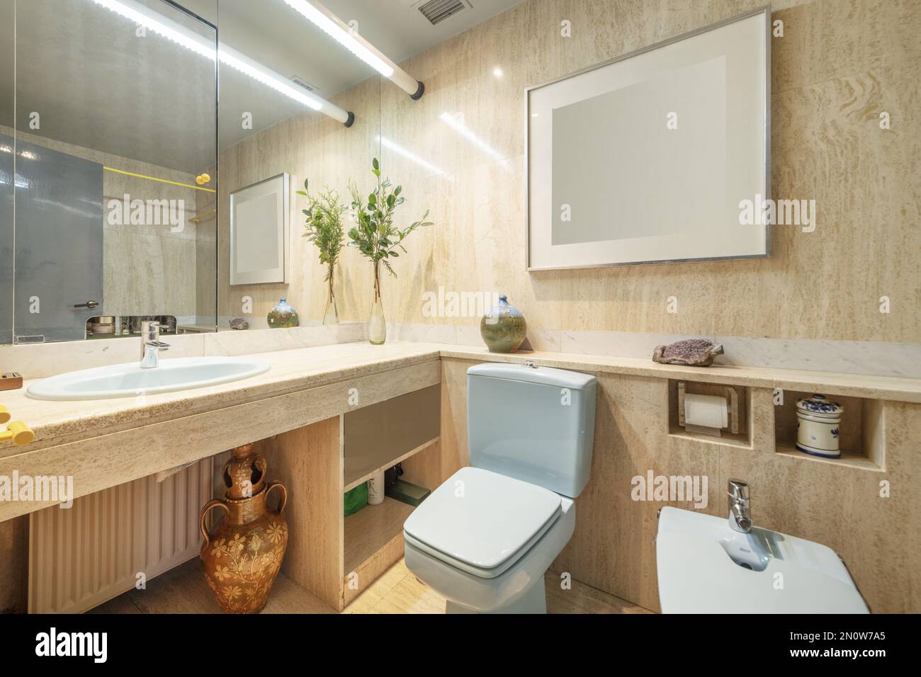 Badezimmer mit hochwertigen Marmormöbeln und Fliesen mit blauem  Porzellanwaschbecken und Spiegel mit versteckter Tür Stockfotografie - Alamy