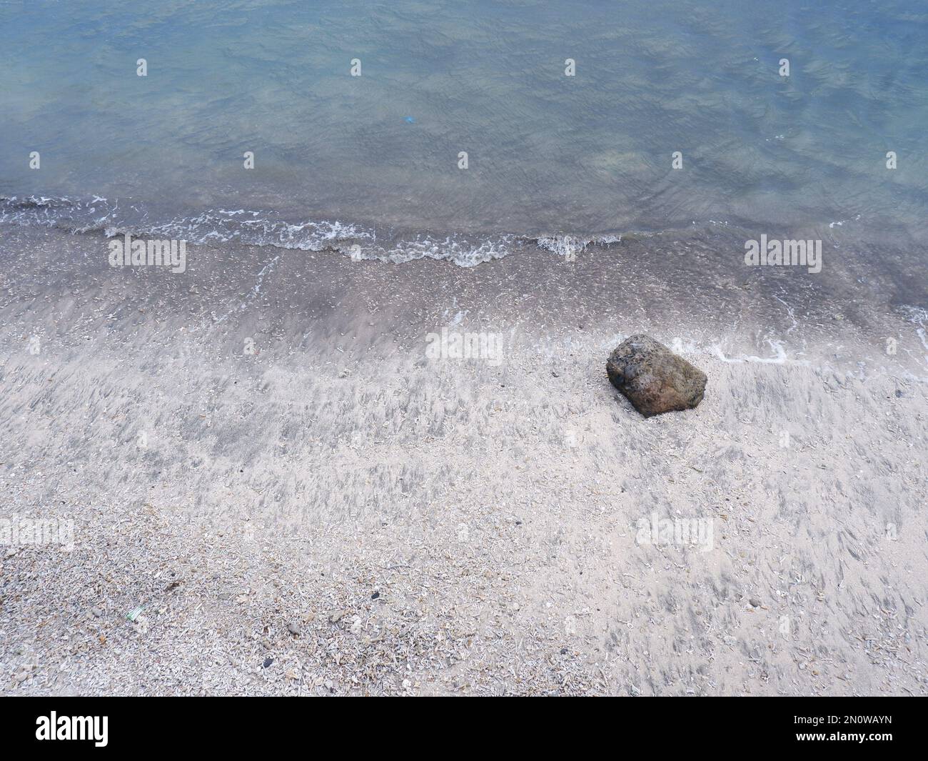 Blick auf die Küste von oben, weiße Wellen, Sandstrand, klares Wasser und Felsen. Panoramablick. Wunderschöne Strände Stockfoto