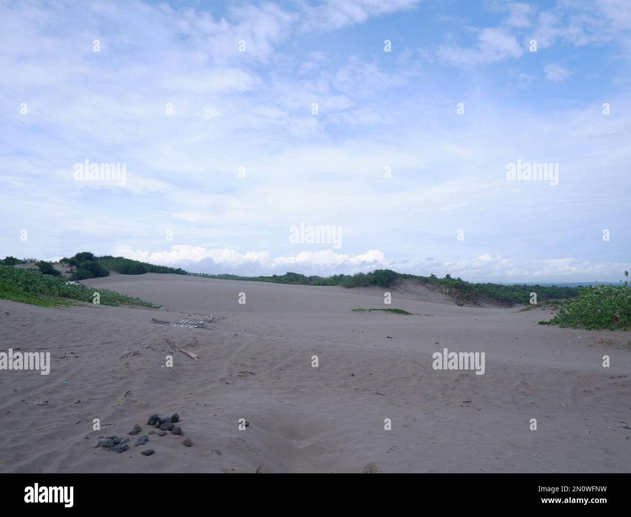 Türkisfarbenes Wasser, weiße Wellen, blauer Himmel, grünes Gras, weißer Sand, Wunderschöner Strand und wunderschöne Insel, Sayang Heulang Garut, Panoramablick Stockfoto