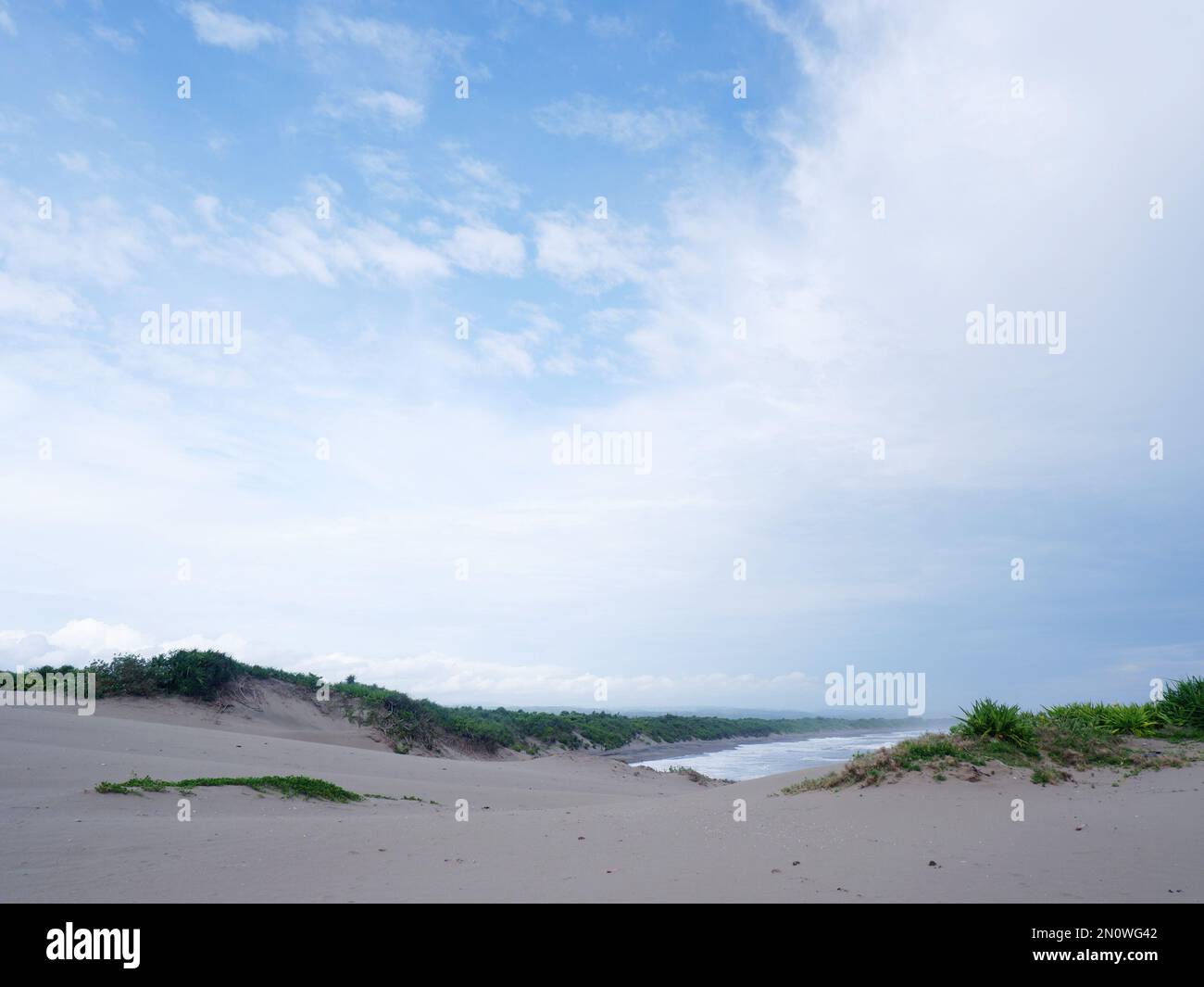 Türkisfarbenes Wasser, weiße Wellen, blauer Himmel, grünes Gras, weißer Sand, Wunderschöner Strand und wunderschöne Insel, Sayang Heulang Garut, Panoramablick Stockfoto