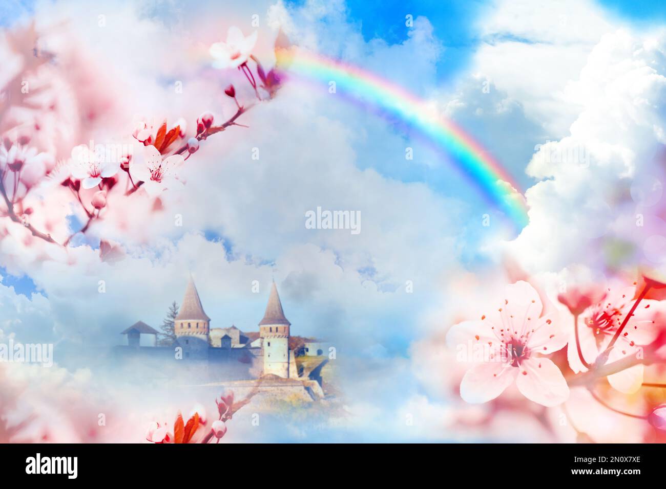 Fantasiewelt. Wunderschöner Regenbogen am Himmel mit flauschigen Wolken über dem verzauberten Schloss Stockfoto