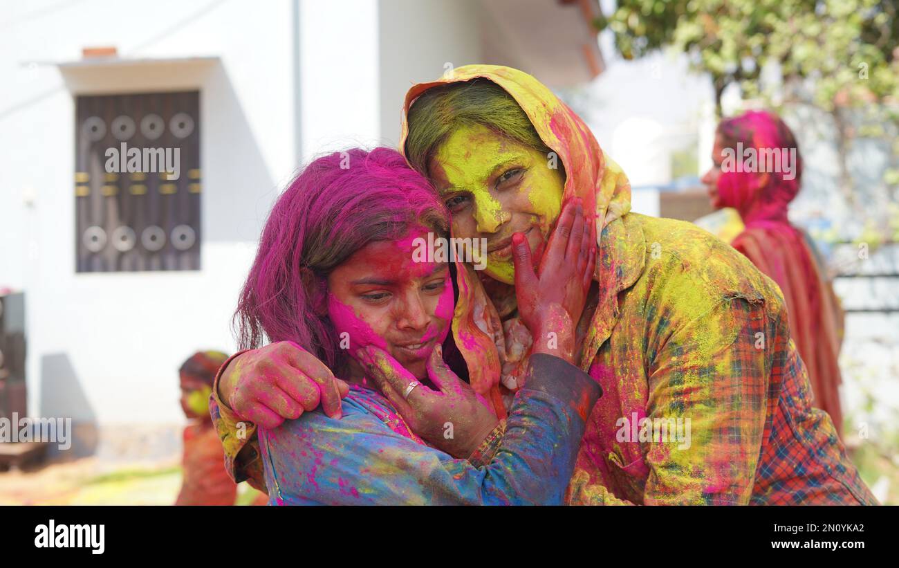 Glückliche Mutter, die sich mit ihrer Tochter zu Hause beim holi Festival amüsiert Stockfoto