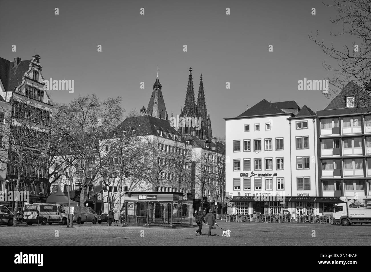 Eine Grauskala-Aufnahme von Gebäuden entlang einer Straße in Köln - Straßenfotografie Stockfoto