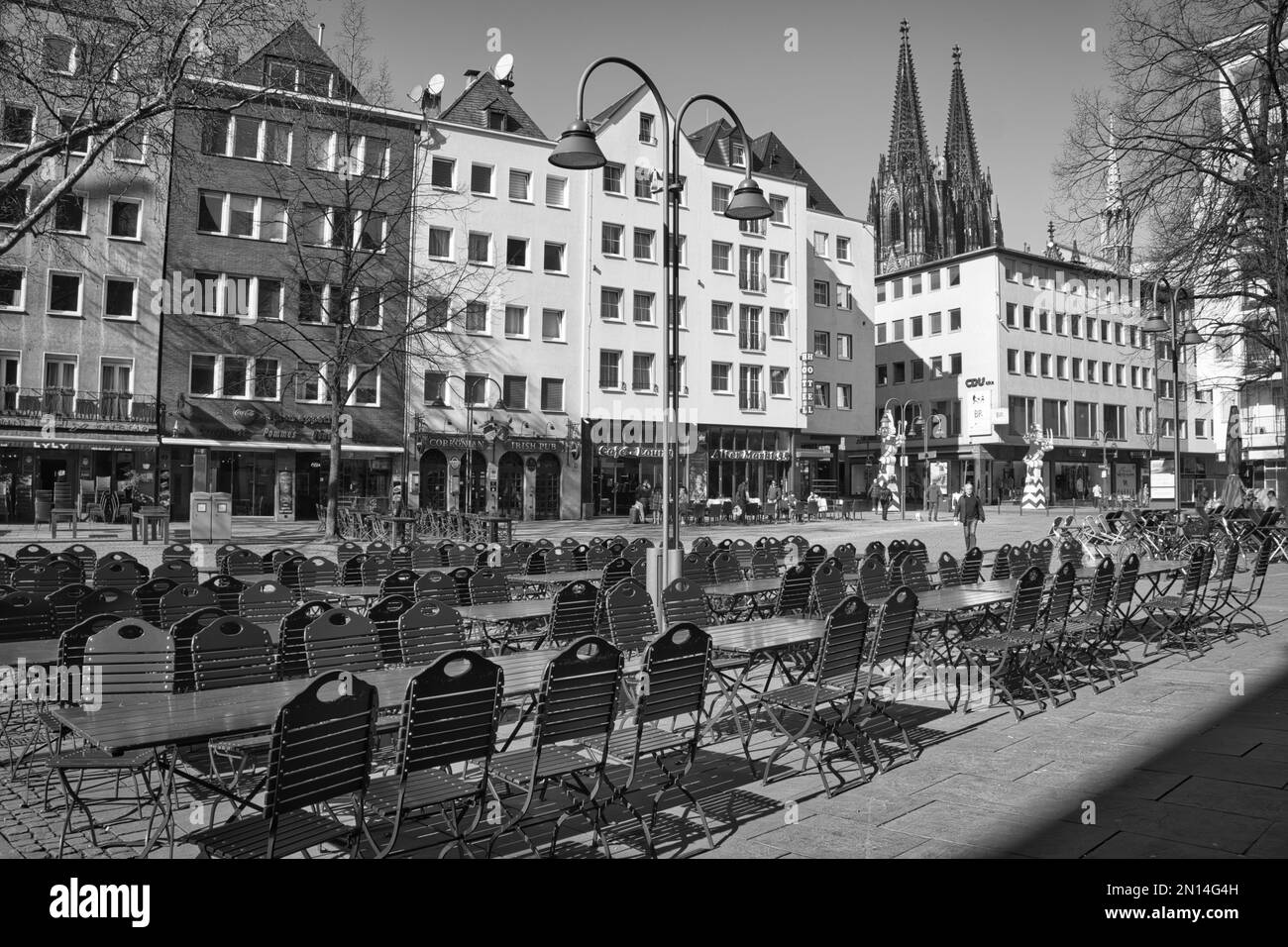 Eine Grauskala-Aufnahme von Gebäuden entlang einer Straße in Köln - Straßenfotografie Stockfoto