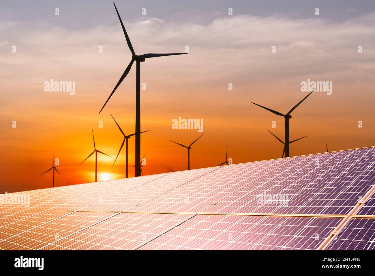 Windturbine und Sonnenkollektor bei Sonnenuntergang. Nachhaltige Energiequelle für intelligente Städte. Stockfoto