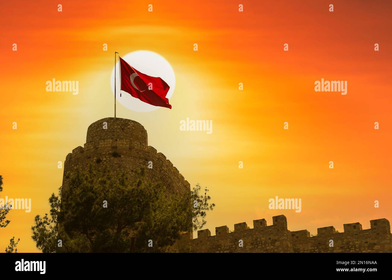 Das Bild des historischen türkischen Schlosses und der türkischen Flagge bei Sonnenuntergang Stockfoto