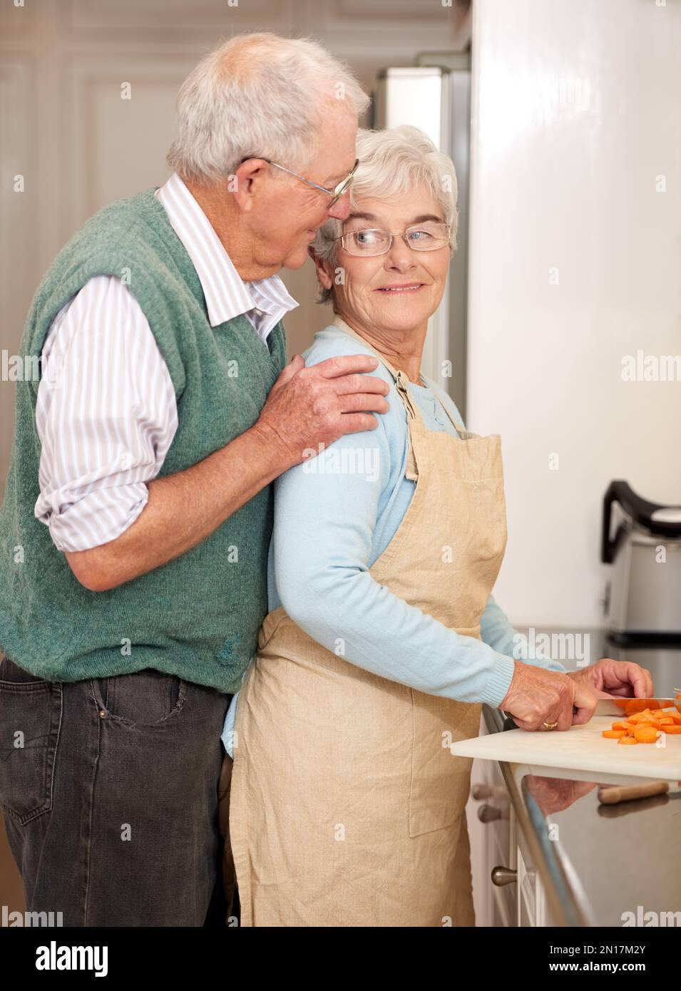 Es riecht köstlich, meine Liebe. Ein Seniorenpaar, das zusammen in der Küche zu Abend kocht. Stockfoto