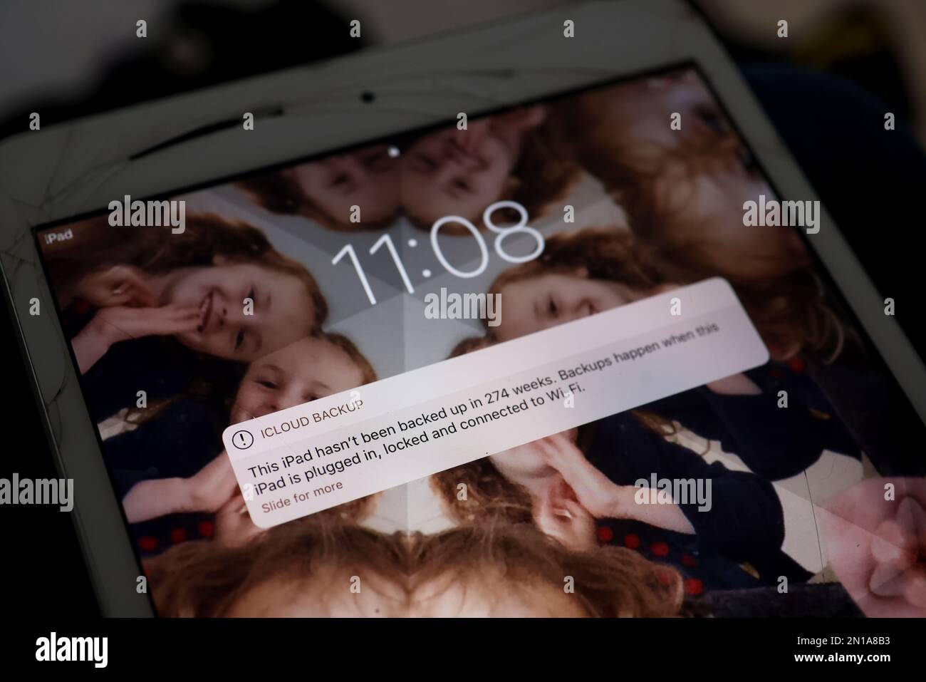 Apple-Geräte mit einer Warnung zum Sichern der Software, die auf dem Bildschirm in London, Großbritannien, angezeigt wird. Stockfoto