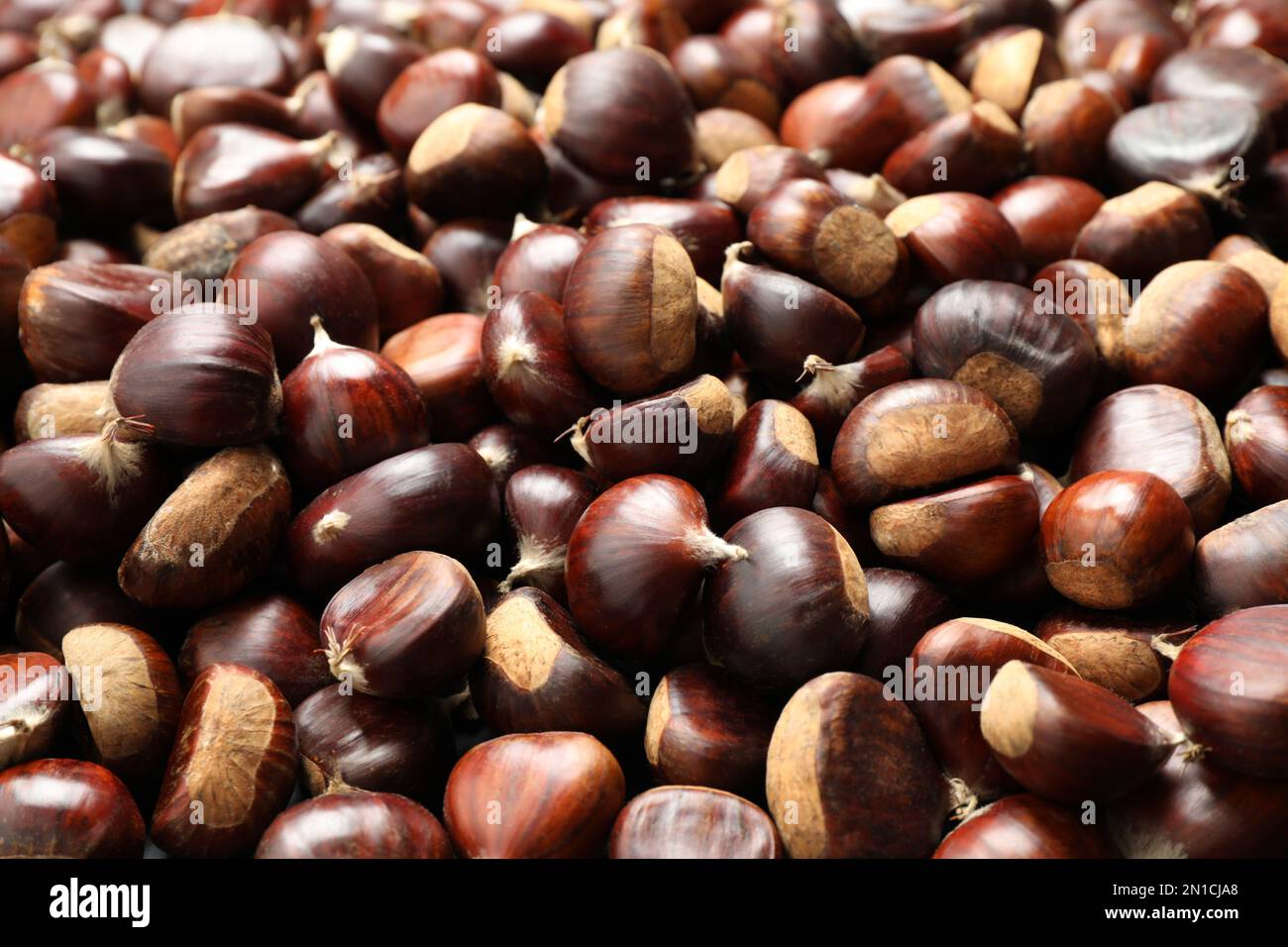 Frische essbare süße Kastanien als Hintergrund, Nahaufnahme Stockfoto