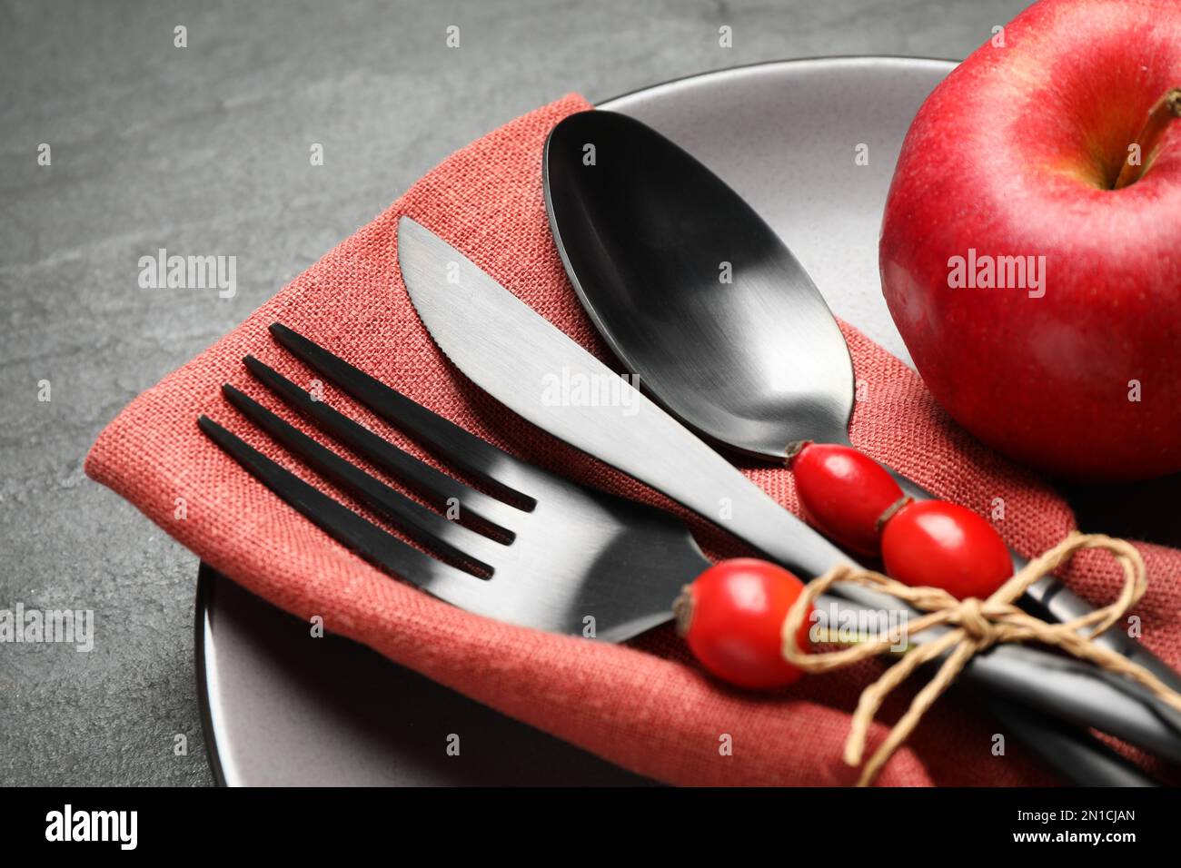 Festlicher Tisch mit Hagebutten und Apfel auf schwarzem Hintergrund, Nahaufnahme. Feierlichkeiten zum Thanksgiving-Tag Stockfoto