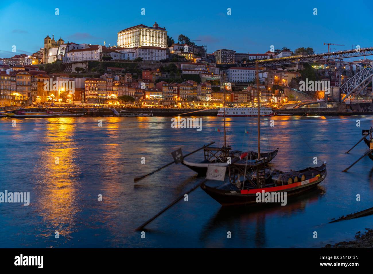 Blick auf den Fluss Douro und Rabelo-Boote, die mit bunten Gebäuden in der Dämmerung, Porto, Norte, Portugal, Europa ausgerichtet sind Stockfoto