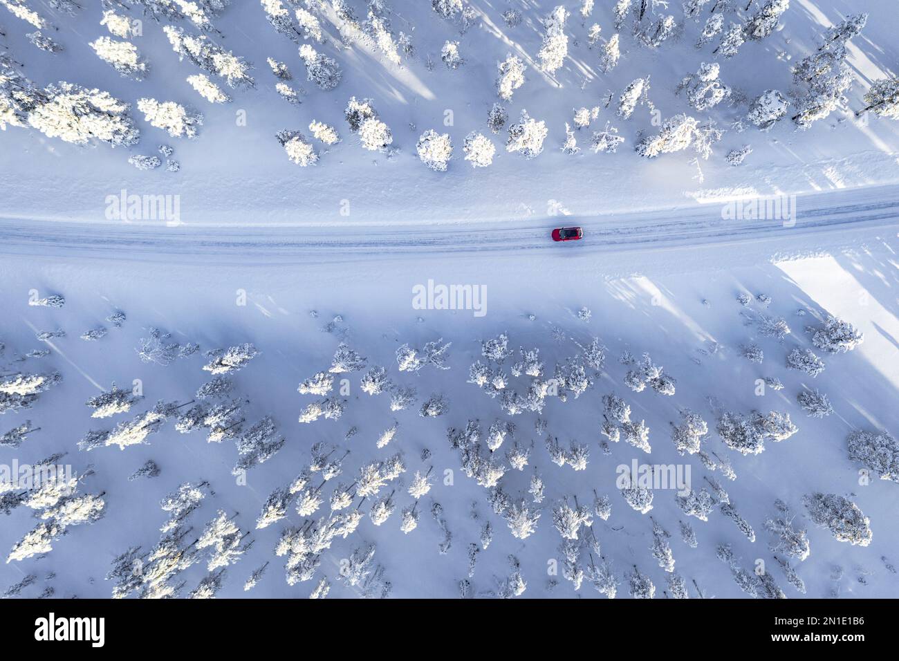 Draufsicht eines Autos, das auf einer kurvenreichen Straße in einem Winterwald mit Schnee fährt, Kangos, Norrbotten County, Lappland, Schweden, Skandinavien, Europa Stockfoto
