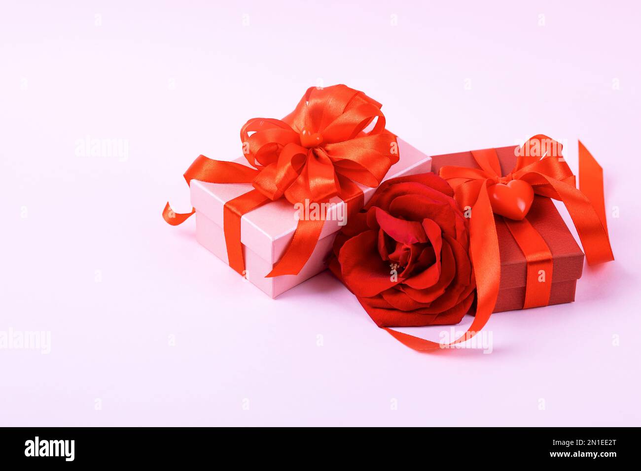 Grußkarte zum Valentinstag, Muttertag und Geburtstag. Rote Rose und Geschenkboxen mit Schleife aus Satin Stockfoto