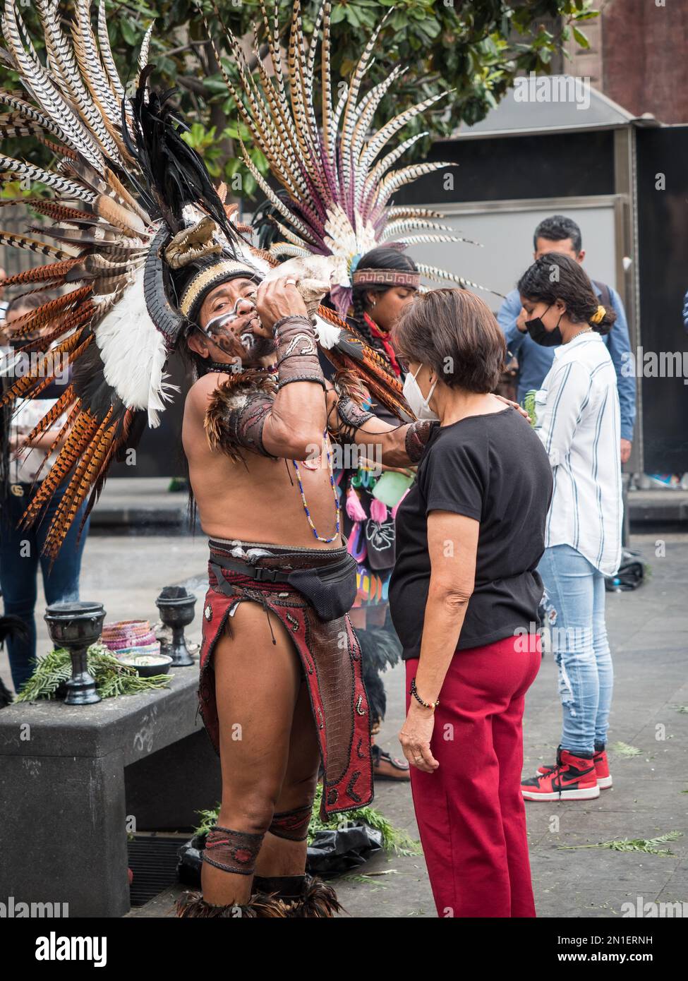 In der Altstadt stehen viele Schlange, um Zeremonien von indigenen Priestern in modernen Versionen der aztekischen Zeremonialkleidung, Mexiko-Stadt, Mexiko zu erhalten Stockfoto