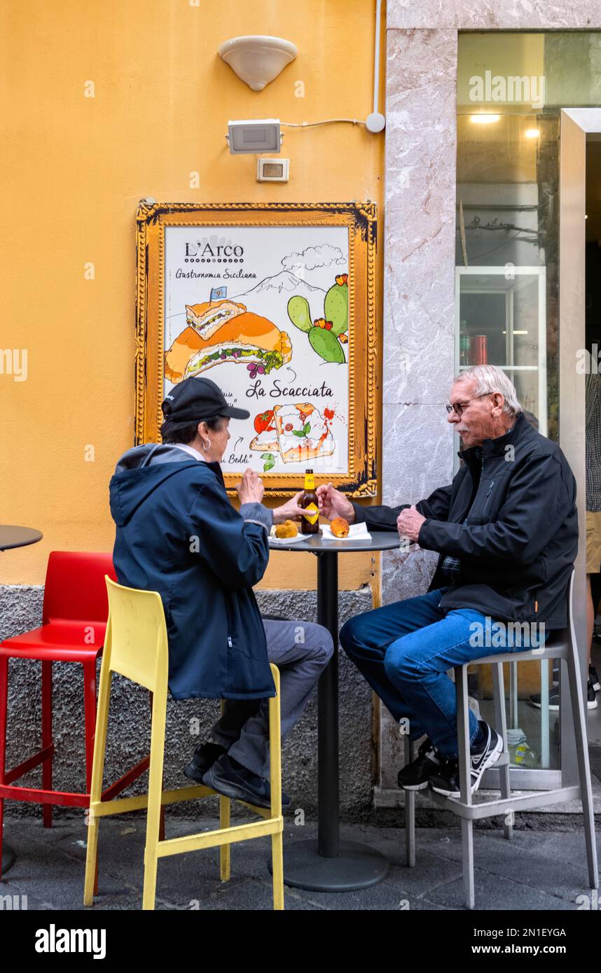 Zwei Personen essen und trinken vor dem L'Arco Restaurant in Taormina, Sizilien, Italien Stockfoto