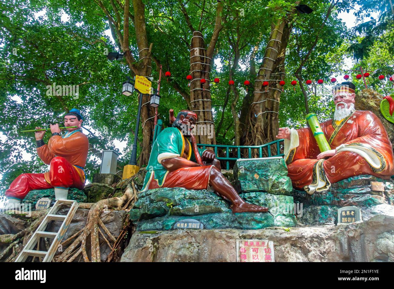 Seremban, Malaysia; Centipede-Tempel, buddhistischer Tempel, Statuen, die die acht Unsterblichen (Xian) darstellen, die auf Felsen inmitten der Bäume sitzen. Stockfoto