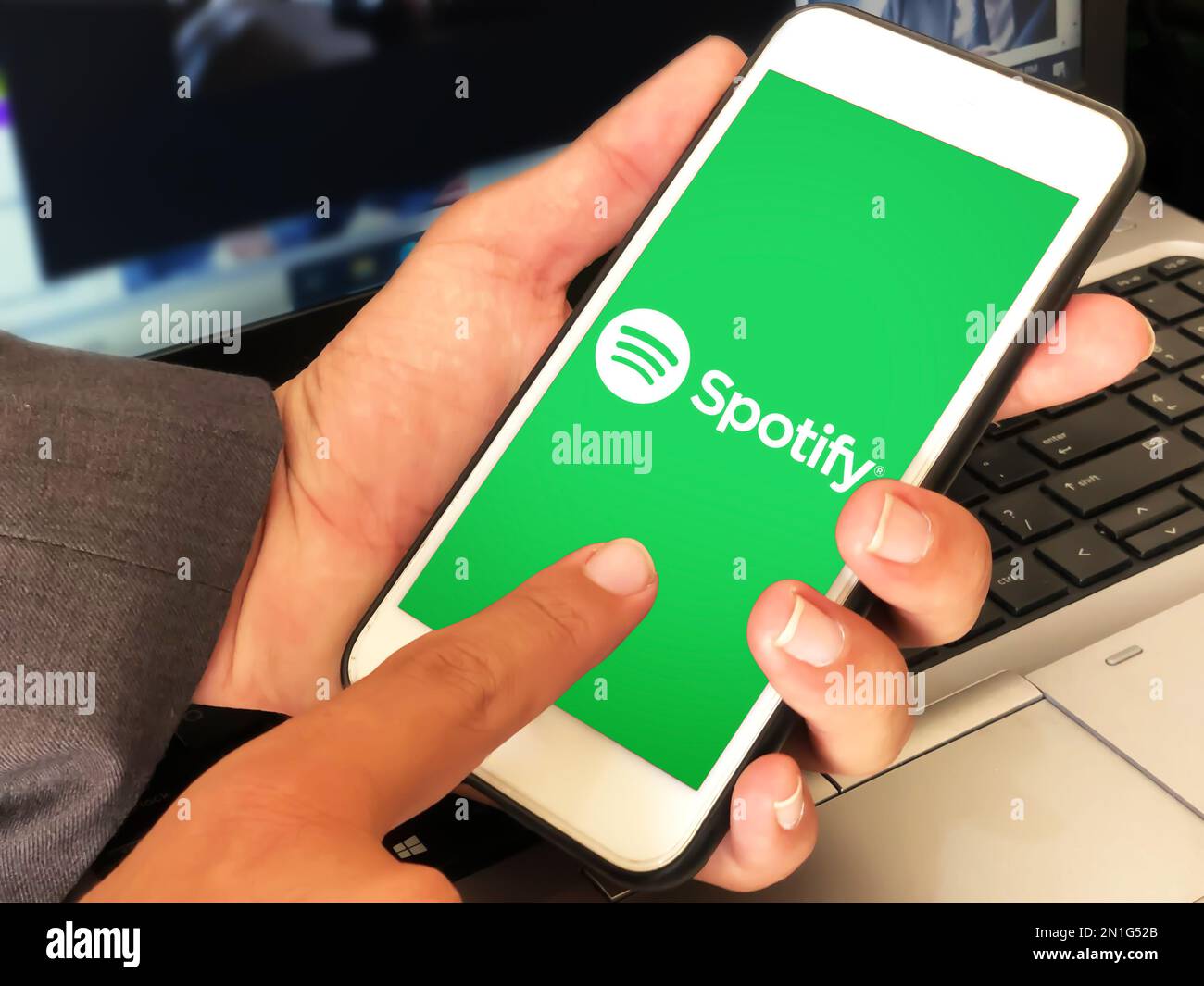 Mann, der die Musikanwendung spotify auf Mobilgeräten verwendet, redaktioneller Hintergrund Stockfoto
