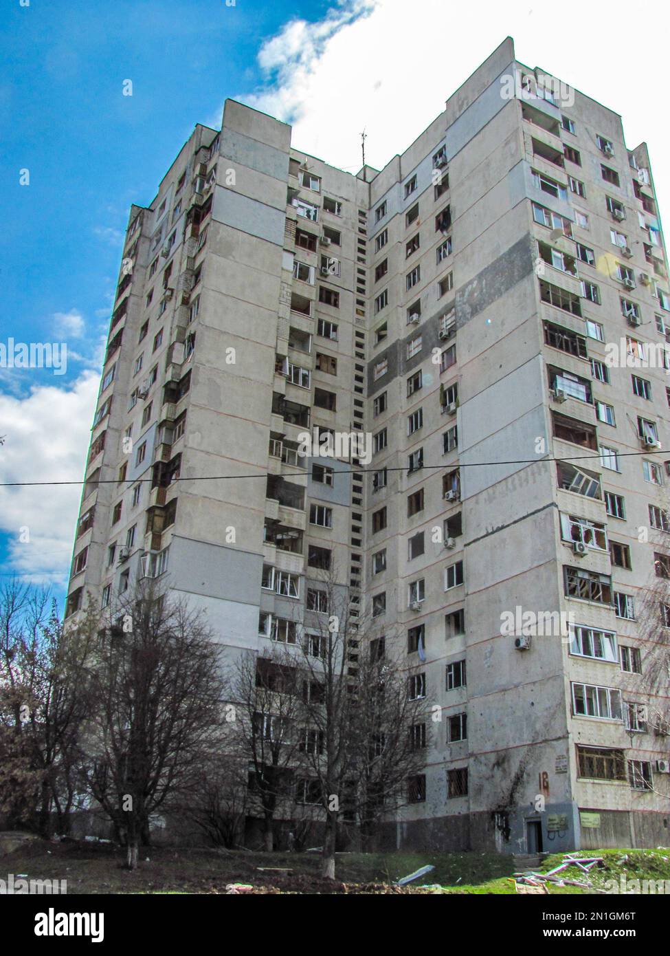 Charkiv, Charkov, Ukraine - 05.07.2022: Von unten beschädigte Wand des Zivilhauses zerstörtes Gebäude Fenster Glasschutt außerhalb von Stockfoto