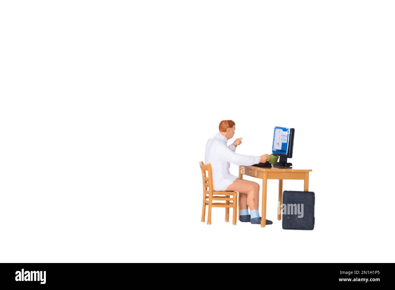 Ein Mann sitzt am Schreibtisch im Heimbüro, isoliert auf weißem Hintergrund Stockfoto