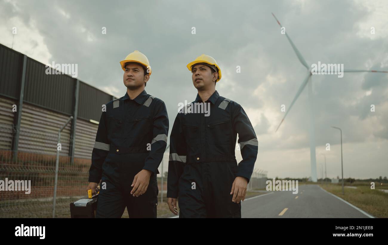 Zwei Techniker in Uniform, der steht und das Kraftwerk des Kraftwerks überprüft. Saubere Energie und Umwelt. Stockfoto