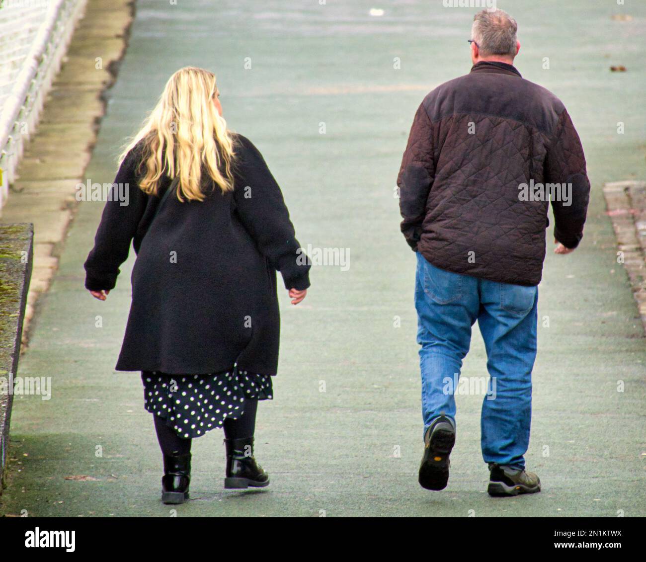 Übergewichtige Menschen, die auf dem Clydeside Walkway auf der Broomielaw laufen Stockfoto