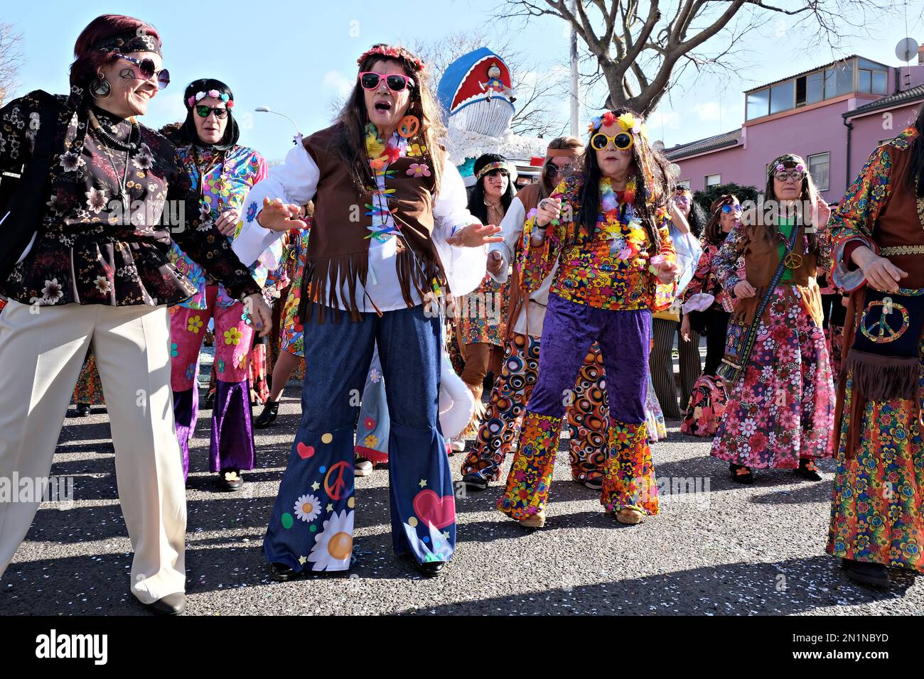 Gruppe reifer Menschen maskiert als Hippies beim Karnevalsumzug tanzt Stockfoto
