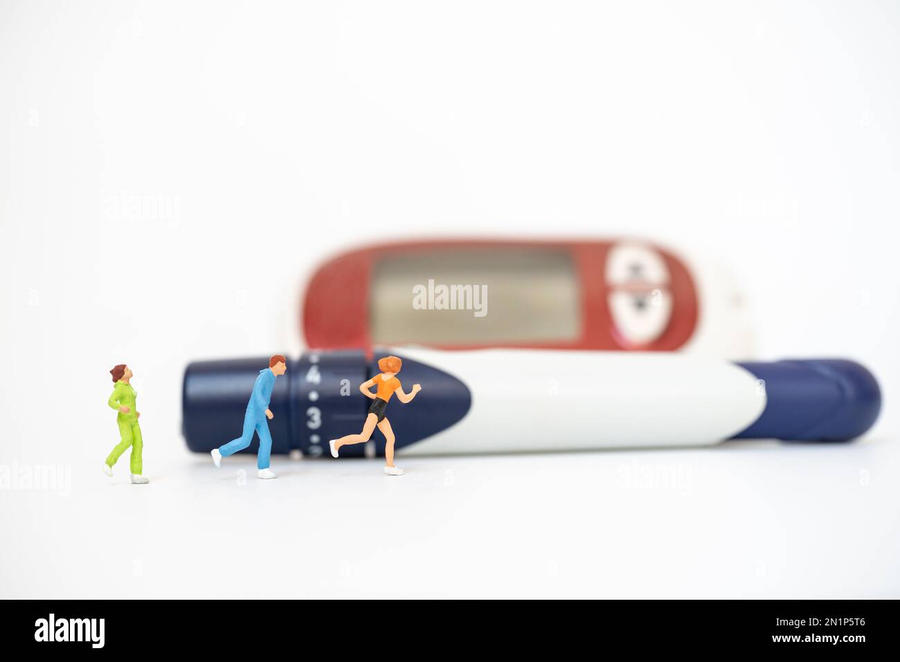 Läufer-Miniaturfigur Leute laufen mit Lanzette und Glukose-Messgerät auf weißem Hintergrund. Verwendung als Sportmedizin, Diabetes, Glykämie, Gesundheitswesen und p Stockfoto