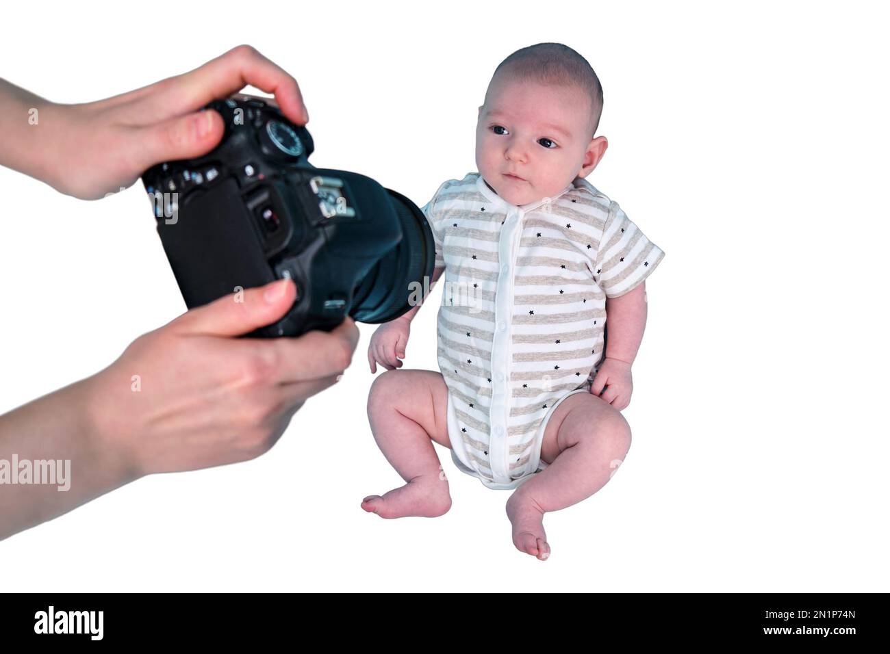 Ein Fotograf fotografiert mit einer Kamera im Studio ein Neugeborenes, isoliert auf weißem Hintergrund. Fotosession von Kindern im Studio. Kleiner Stockfoto