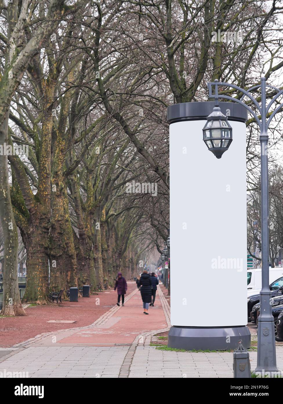 Leere Werbesäule in einer Stadt mit kostenlosem Werbespot, Werbemodell. Leere Anzeigetafel. Nicht identifizierbare Fußgänger mit Bewegungsunschärfe Stockfoto