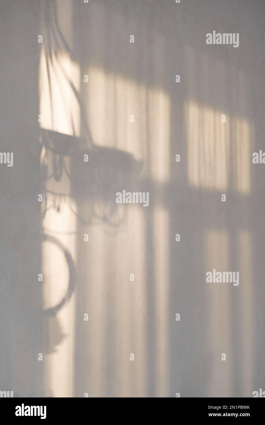 Minimalistischer abstrakter, sanfter Hintergrund für Produktpräsentation mit Licht und Schatten von Fenstervorhängen an der Wand. Stockfoto