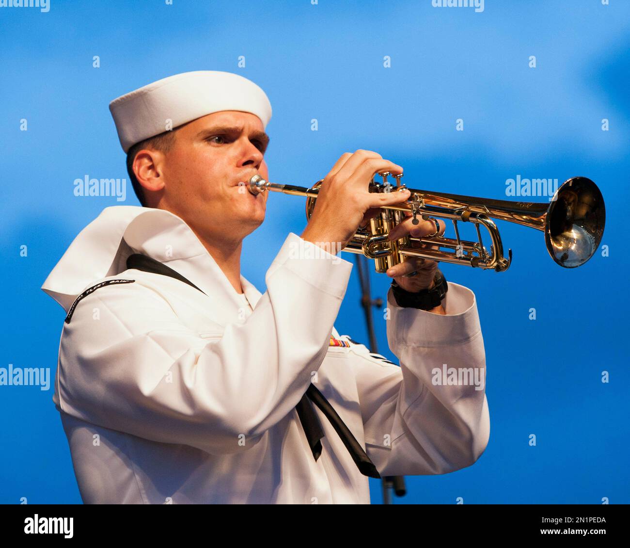 Navy bugler Rick Batey plays on stage before the start of fireworks marking the 70th anniversary of the end of World War II at Joint Base Pearl Harbor-Hickam, Saturday, Aug. 15, 2015, in Honolulu. (AP Photo/Marco Garcia) Stockfoto