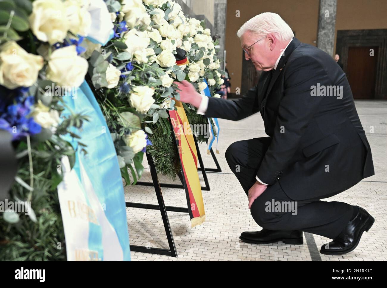 München, Deutschland. 06. Februar 2023. Der deutsche Präsident Frank-Walter Steinmeier kniet während der Kranzlegen-Zeremonie am Weißen Rosendenkmal im Atrium nieder. Steinmeier forderte die deutsche Demokratie, sich gegen neue Bedrohungen von außen und zunehmende Angriffe von innen verteidigen zu können. Kredit: Britta Pedersen/dpa/Alamy Live News Stockfoto