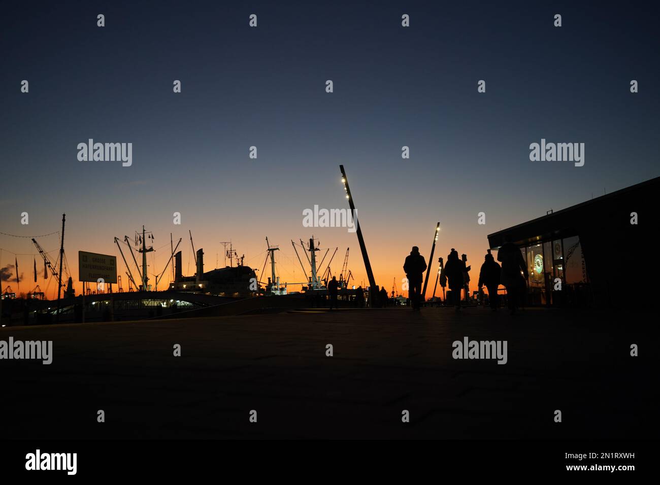 Hamburg, Deutschland. 06. Februar 2023. Passanten gehen entlang der Jan Fedder Promenade im Hafen in der Abendsonne. Kredit: Marcus Brandt/dpa/Alamy Live News Stockfoto