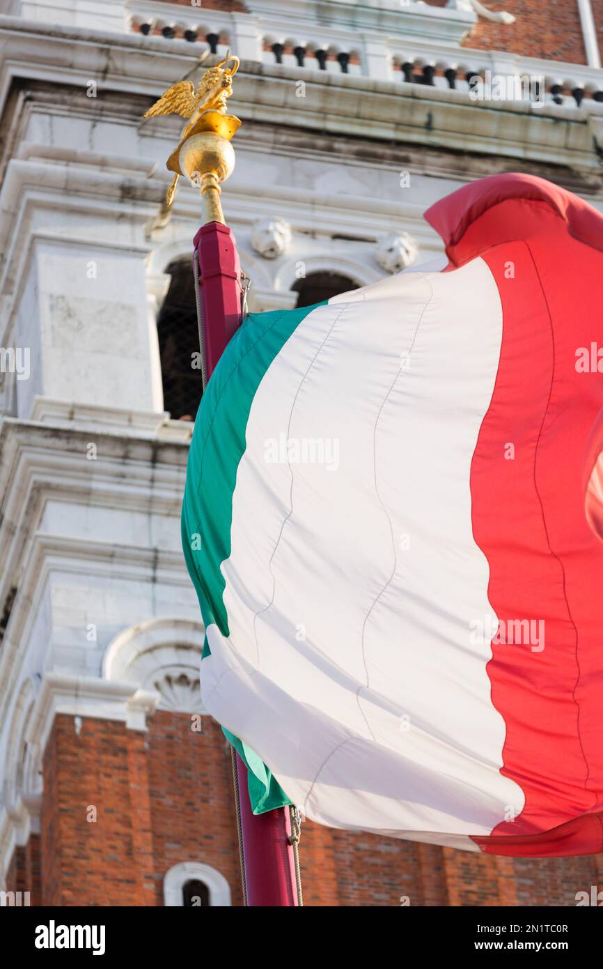 Italien, Venedig, italienische Flagge mit dem Markusdom Campanile im Hintergrund. Stockfoto