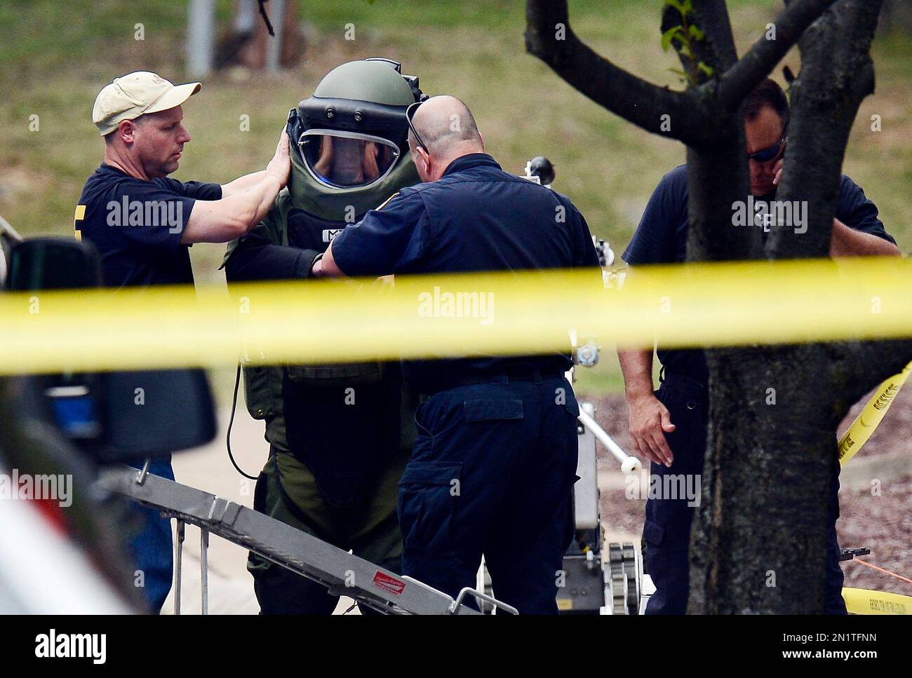 A member of the Nashville Metro Police Bomb Squad unit suits up before checking a device on the side of a movie theater following a shooting Wednesday, Aug. 5, 2015, in Antioch, Tenn. A man armed with a hatchet and gun unleashed a volley of pepper spray at audience members inside a movie theater, exchanging fire with a responding officer before being shot dead as he tried to escape out the back of the theater only to encounter a SWAT team, police said. (AP Photo/Mark Zaleski) Stockfoto