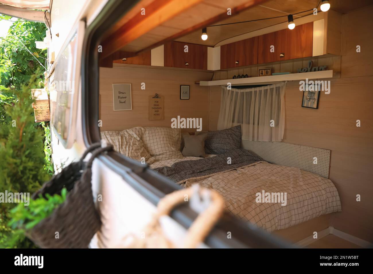 Stilvolle Einrichtung mit komfortablem Bett und Kissen in einem modernen  Wohnwagen, Blick von außen. Campingurlaub Stockfotografie - Alamy