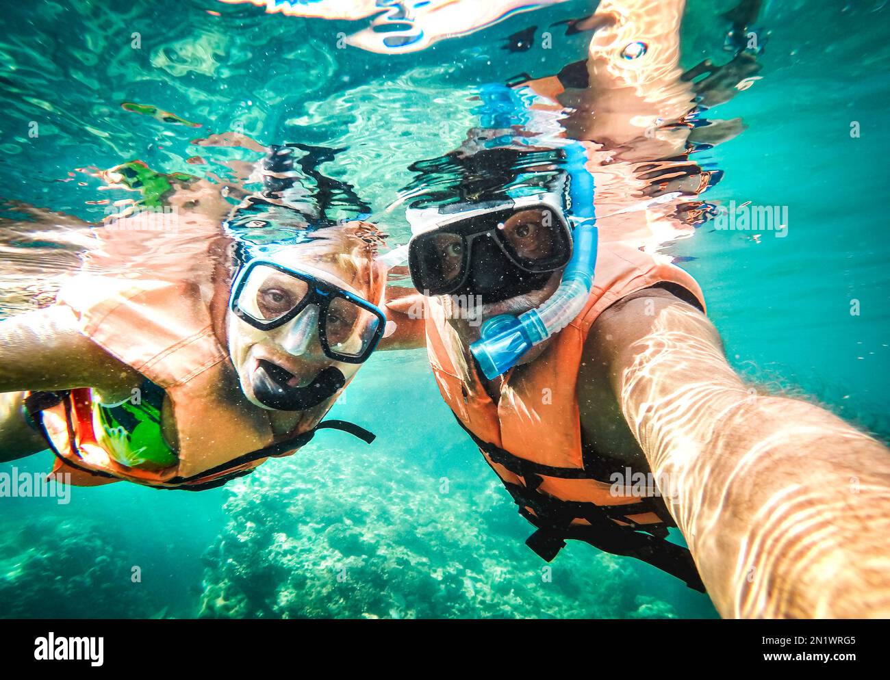 Aktives Seniorenpaar, das unter Wasser Selfie auf einem tropischen Meeresausflug mit Wasserkamera machte - Bootsausflug Schnorcheln in exotischen Szenarien - Rentner Stockfoto