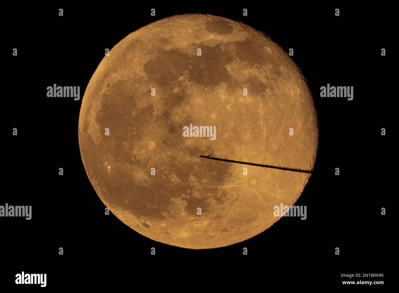 London, Großbritannien. 6. Februar 2023 Das Flugzeug fliegt durch den Mond. Ein Passagierjet, der vom Flughafen London City abhebt, durchquert einen 99,1% Vollmond, der über der Stadt aufsteigt. Kredit: Guy Corbishley/Alamy Live News Stockfoto