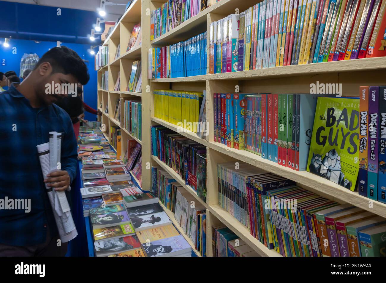 Kolkata, Westbengalen, Indien - 2. Februar 2020 : junger Mann mit der Karte der Buchmesse in der Hand, liest Bucheinbände von ausgestellten Büchern, Buchmesse. Stockfoto