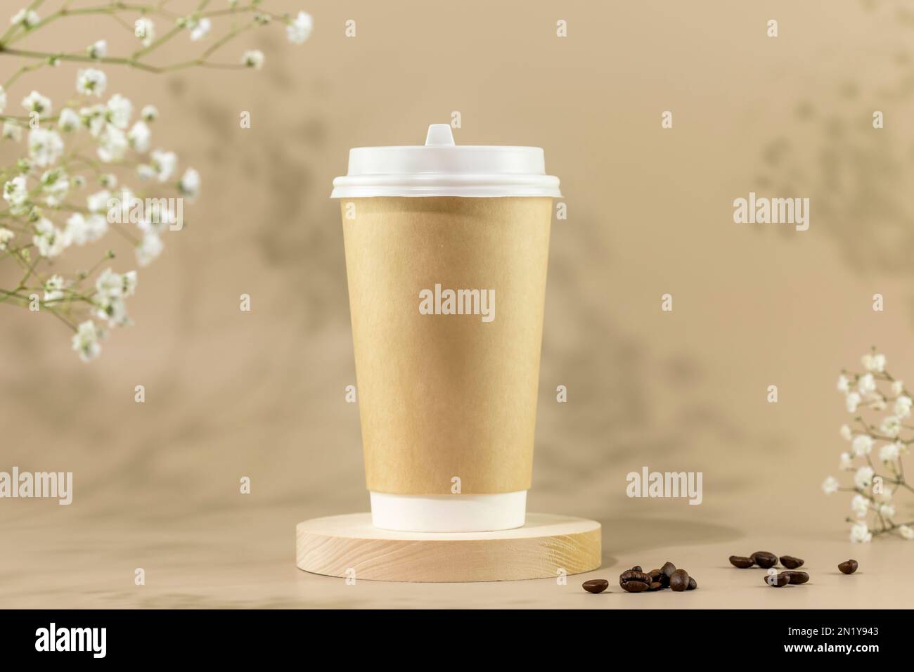 Kaffee zum Mitnehmen. Frühlingszusammensetzung mit umweltfreundlichem  Einweg-Pappbecher mit Kaffeebohnen auf beigefarbenem Hintergrund mit weißen  Blumen. Kaffee zum Mitnehmen Stockfotografie - Alamy