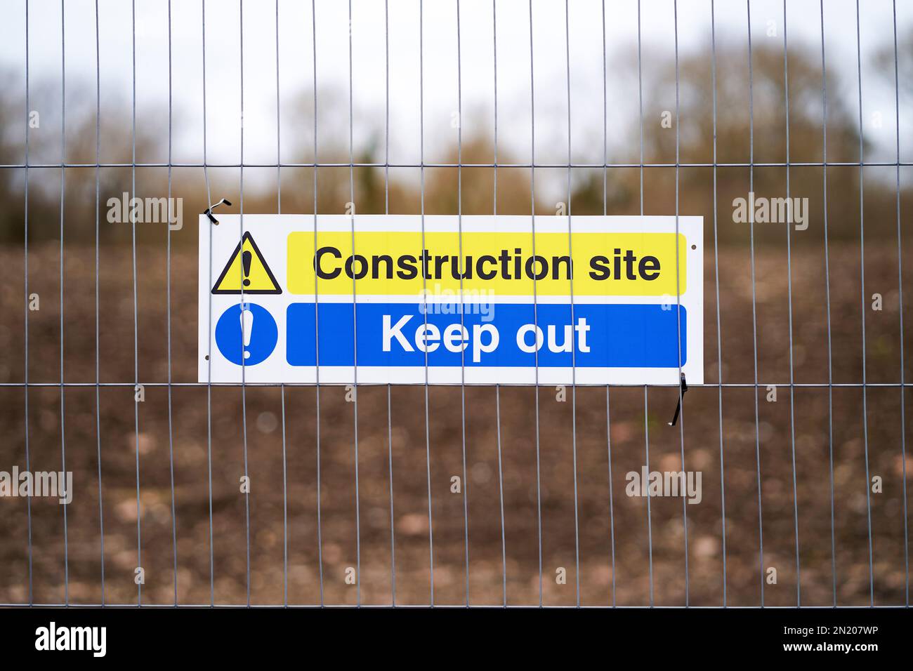 Baustellenschild am Drahtzaun Stockfoto