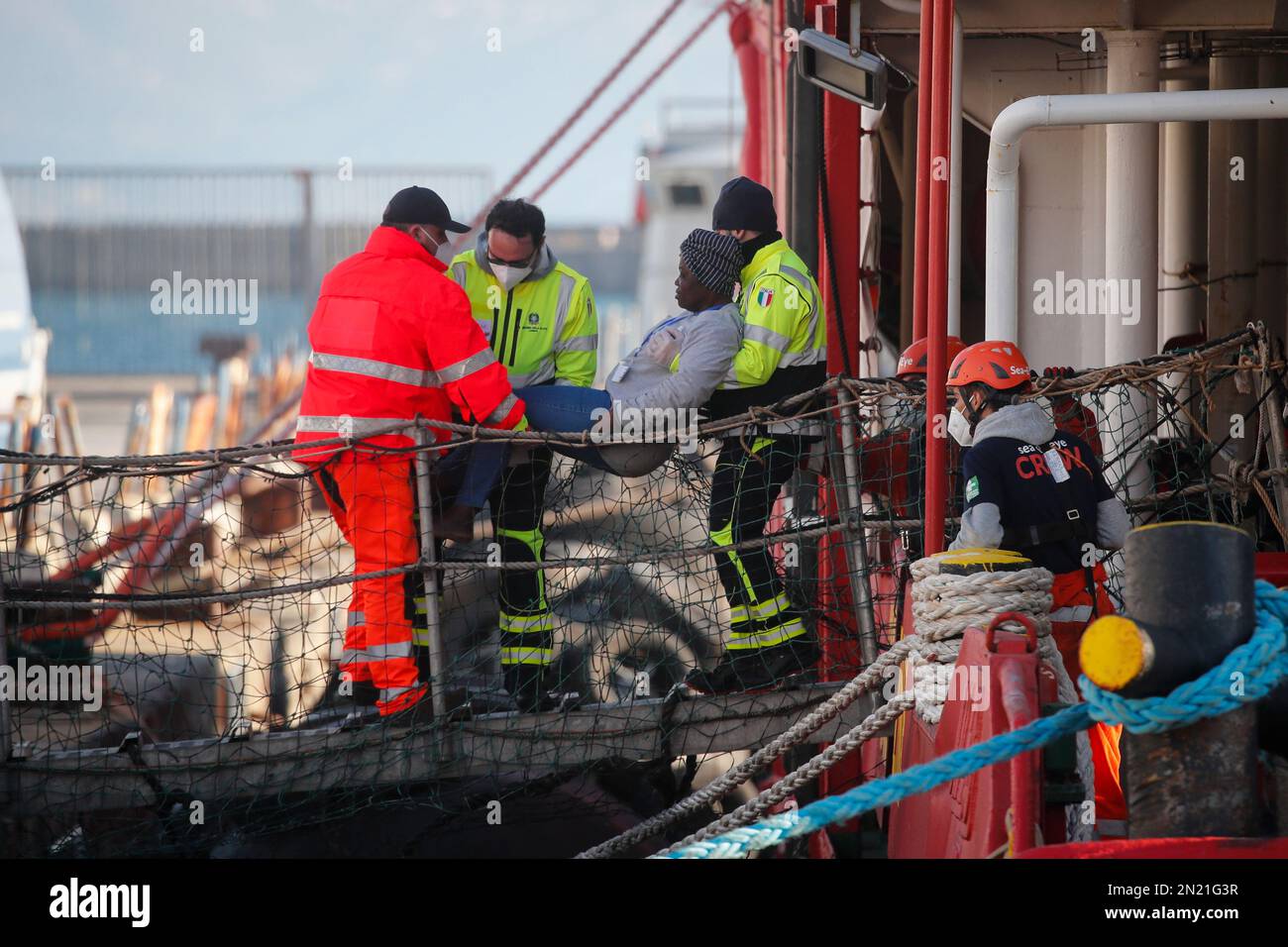 Neapel, Italien. 06. Februar 2023. Den Menschen wird geholfen, das Rettungsschiff Sea-Eye 4 zu verlassen, nachdem es mit 106 Migranten an Bord im Hafen von Neapel angedockt hat. Das Schiff sollte im Hafen von Pesaro anlegen, aber es wurde schließlich genehmigt, seine Passagiere in Neapel aufgrund rauer Seebedingungen aussteigen zu lassen. Kredit: Unabhängige Fotoagentur/Alamy Live News Stockfoto