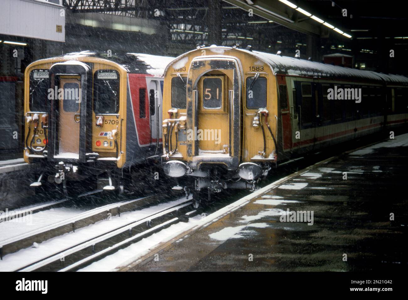 1583 4-CEP und 5709-EMUs der Klasse 455, die inmitten eines Schneesturms in London Waterloo zu sehen waren - aufgenommen am 6. Februar 1991. Stockfoto