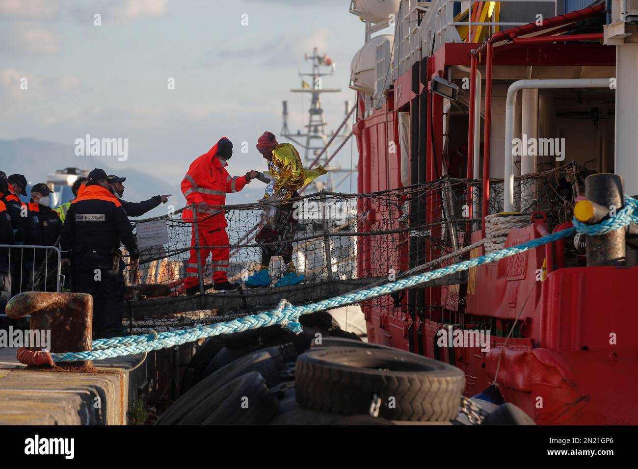 Neapel, Italien. 06. Februar 2023. Den Menschen wird geholfen, das Rettungsschiff Sea-Eye 4 zu verlassen, nachdem es mit 106 Migranten an Bord im Hafen von Neapel angedockt hat. Das Schiff sollte im Hafen von Pesaro anlegen, aber es wurde schließlich genehmigt, seine Passagiere in Neapel aufgrund rauer Seebedingungen aussteigen zu lassen. Kredit: Unabhängige Fotoagentur/Alamy Live News Stockfoto