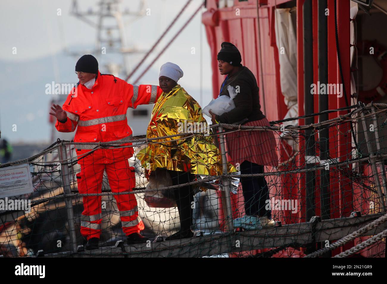 Neapel, Italien. 06. Februar 2023. Den Menschen wird geholfen, das Rettungsschiff Sea-Eye 4 zu verlassen, nachdem es mit 106 Migranten an Bord im Hafen von Neapel angedockt hat. Das Schiff sollte im Hafen von Pesaro anlegen, aber es wurde schließlich genehmigt, seine Passagiere in Neapel aufgrund rauer Seebedingungen aussteigen zu lassen. Kredit: Unabhängige Fotoagentur/Alamy Live News Stockfoto