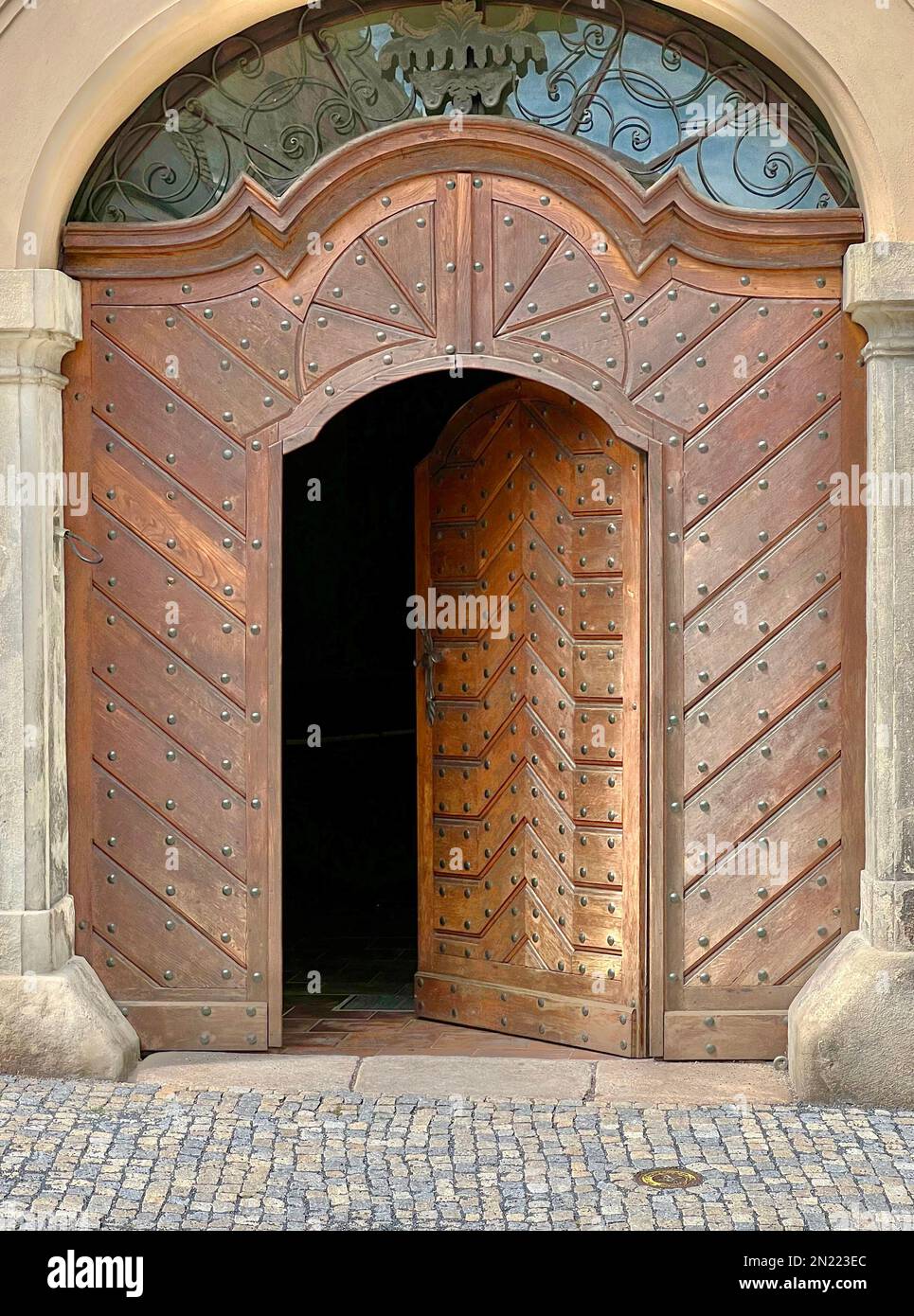 Große Nagelköpfe schmücken die abgeschrägten Holzpaneele an dieser historischen Tür in Kutna Hora, Tschechien. Türverkleidungen aus Metall sind in dieser silbernen Stadt. Stockfoto