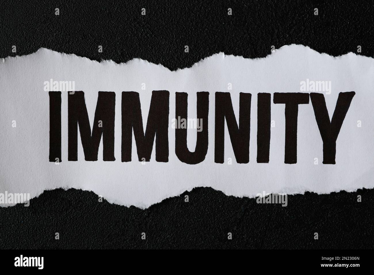 Ein Stück Papier mit dem Wort "Immunität" auf dem schwarzen Tisch, Draufsicht Stockfoto