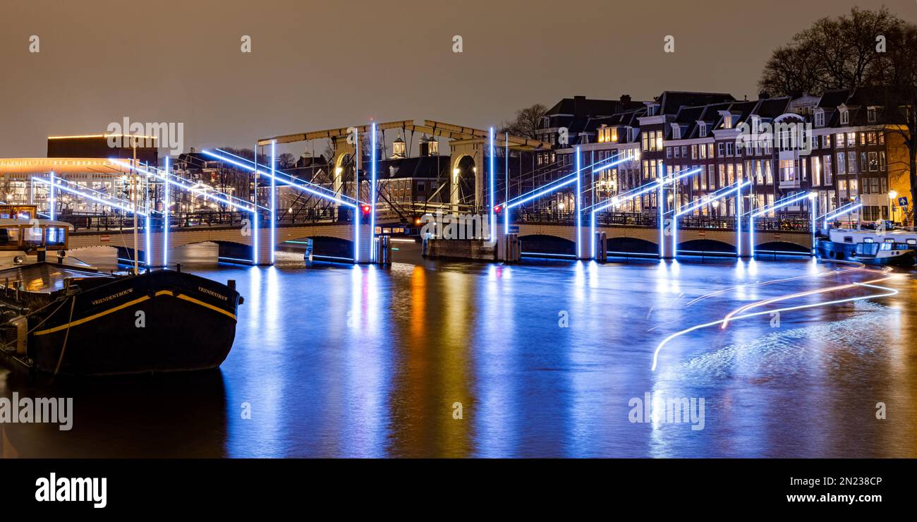 AMSTERDAM, NIEDERLANDE - 18. JANUAR 2023: Amsterdam Light Festival - Brücke 242 (Magere Brücke) an der Amstel. Panoramablick. Stockfoto