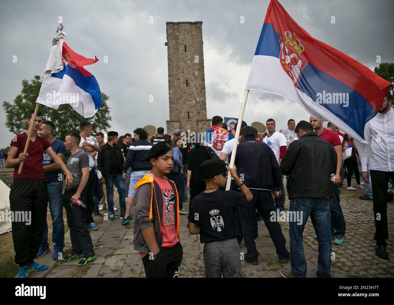Kosovo Serbs wave Serbian flags near a monument to the historic battle at Gazimestan, near capital Pristina, Kosovo, Sunday, June 28, 2015. Hundreds of Serbs gathered on Sunday to mark the 626th anniversary of the battle where the Serbian army was defeated by the Ottoman Empire. (AP Photo/Visar Kryeziu) Stockfoto